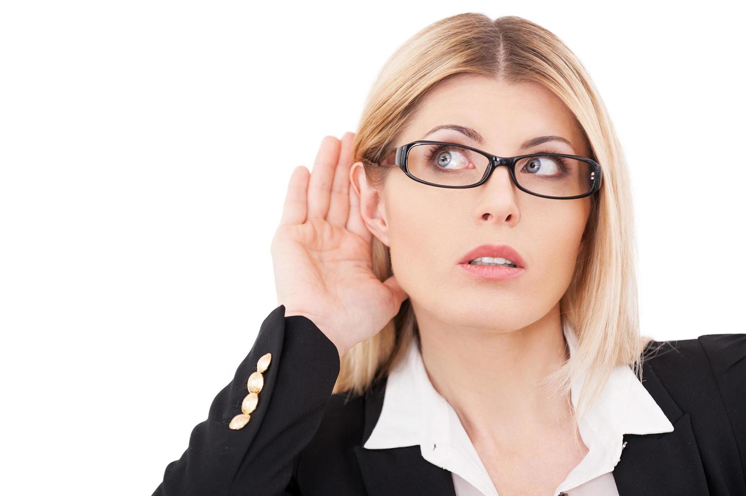 femme d'affaires curieuse. belle femme d'affaires mature écoutant en se tenant debout isolé sur blanc photo