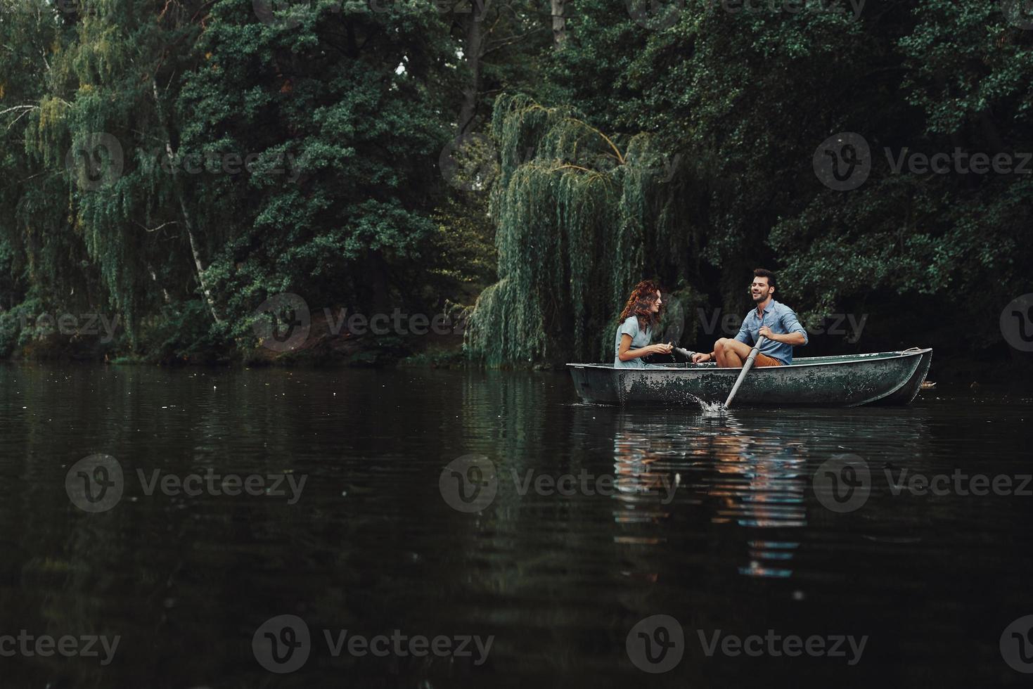 journée insouciante ensemble. beau jeune couple souriant tout en profitant d'un rendez-vous romantique sur le lac photo