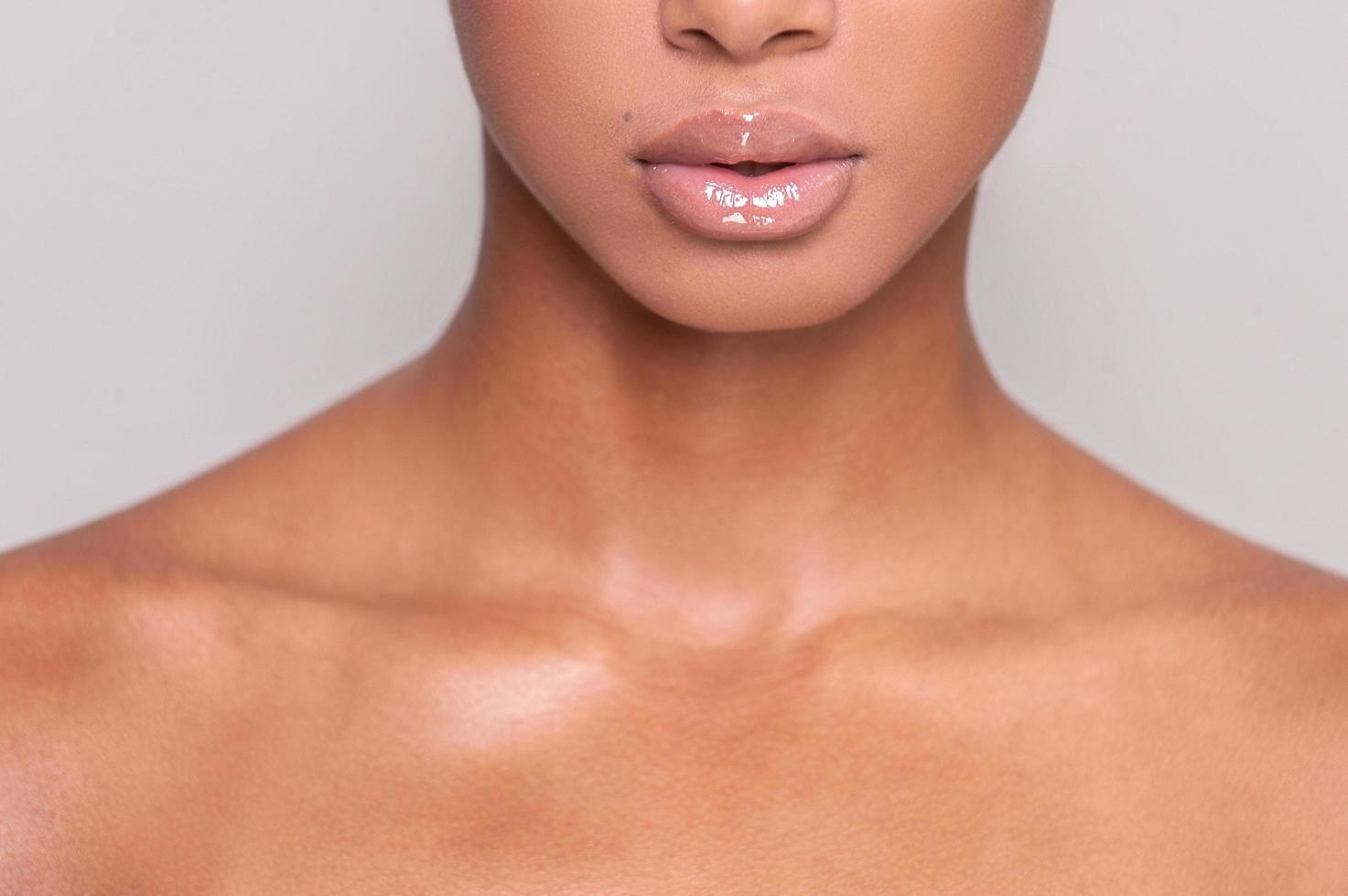 belles lèvres. image recadrée d'une belle jeune femme afro-américaine torse nu debout tout en étant isolée sur fond gris photo