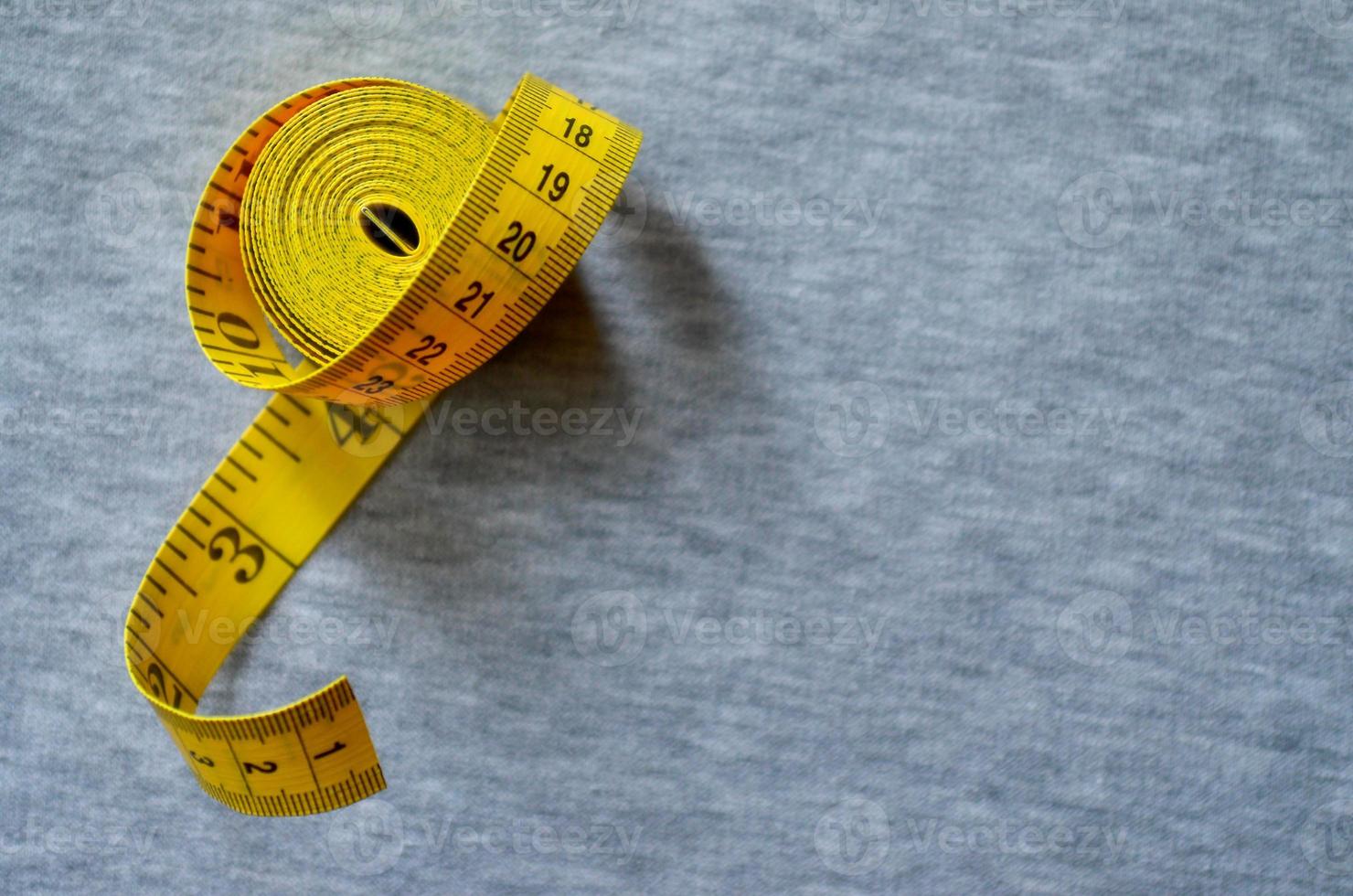 ruban à mesurer jaune se trouve sur un tricot gris photo