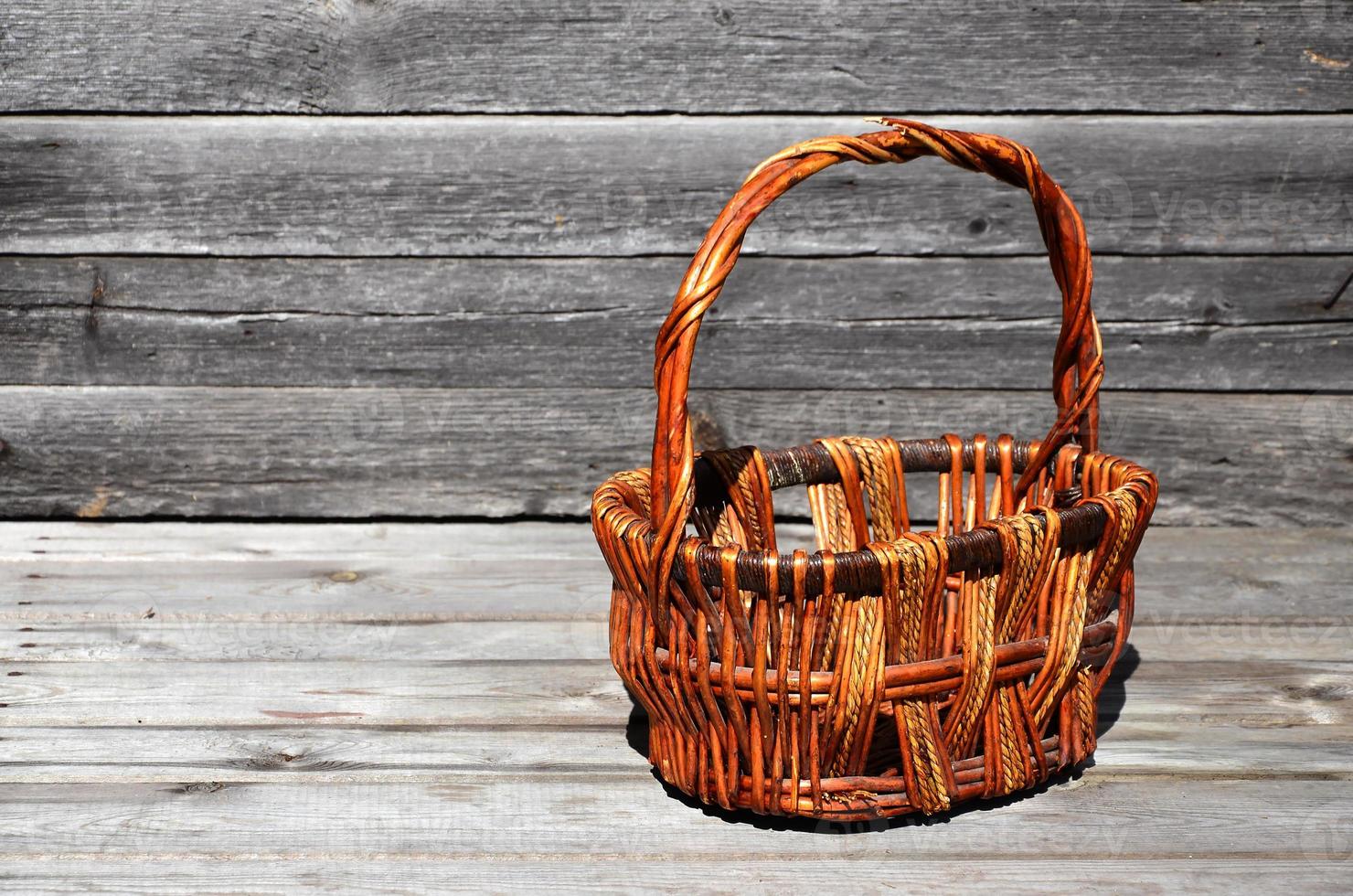 un panier en osier vide de tiges de bois se trouve sur une surface en bois photo