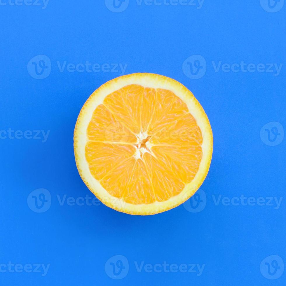 vue de dessus d'une tranche de fruit orange sur fond clair de couleur bleue. une image de texture saturée d'agrumes photo