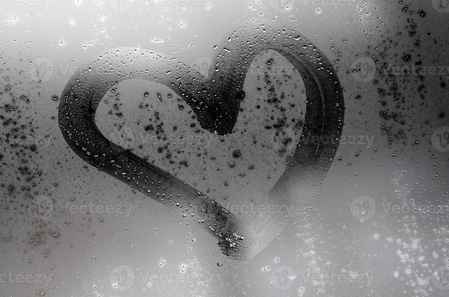 le coeur est peint sur le verre embué en hiver photo