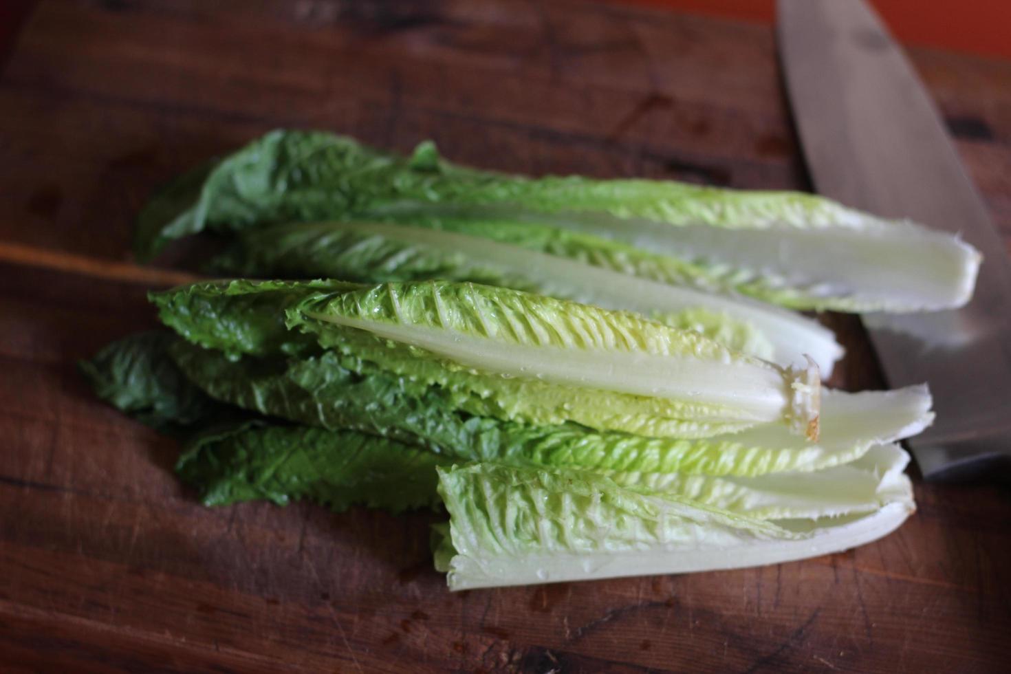 les légumes préparés pour être hachés sont sur une planche à découper en bois avec un couteau. photo