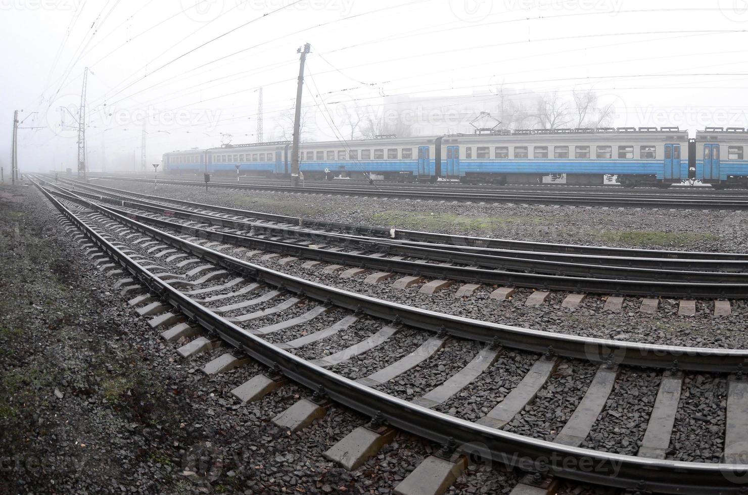 le train de banlieue ukrainien se précipite le long de la voie ferrée par un matin brumeux. photo fisheye avec distorsion accrue