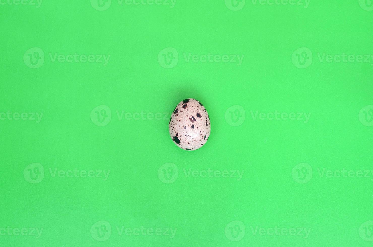 un oeuf de caille sur une surface vert clair, vue de dessus, place vide pour photo
