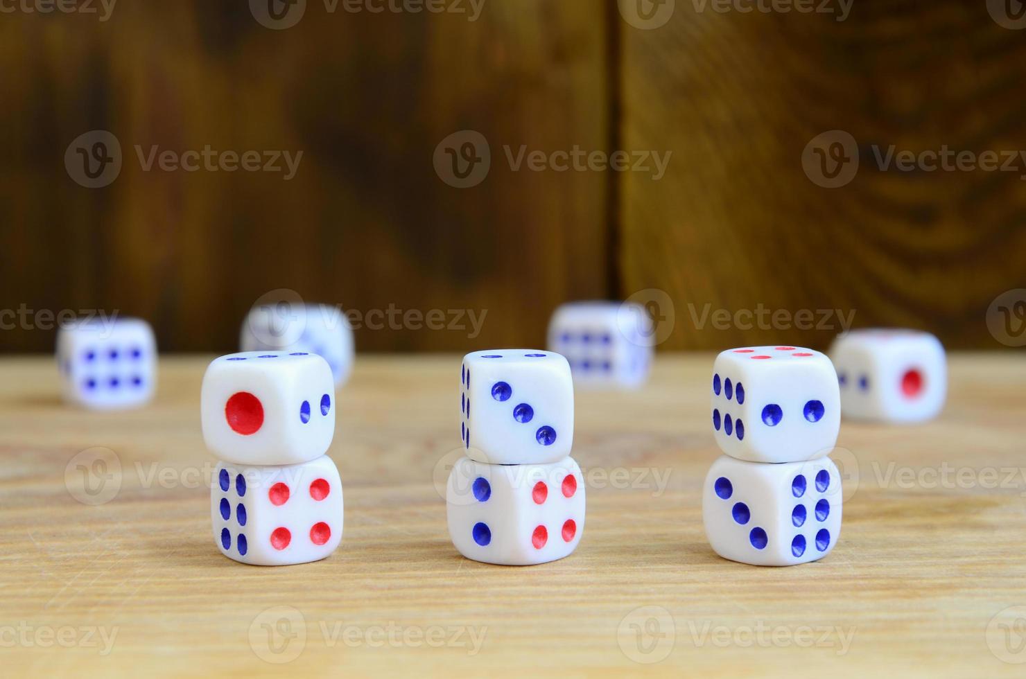 quelques dés reposent sur la surface du bois naturel. éléments pour générer des nombres de un à six sous la forme de points qui sont peints sur le côté des cubes. le concept de jeu photo