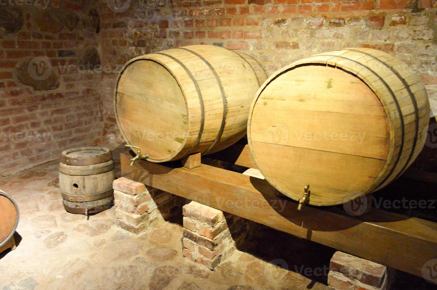 grands fûts ronds en bois pour la bière, le vin dans l'ancienne cave du moyen âge en brique photo