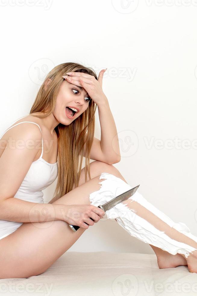 femme se rase les jambes avec un couteau photo