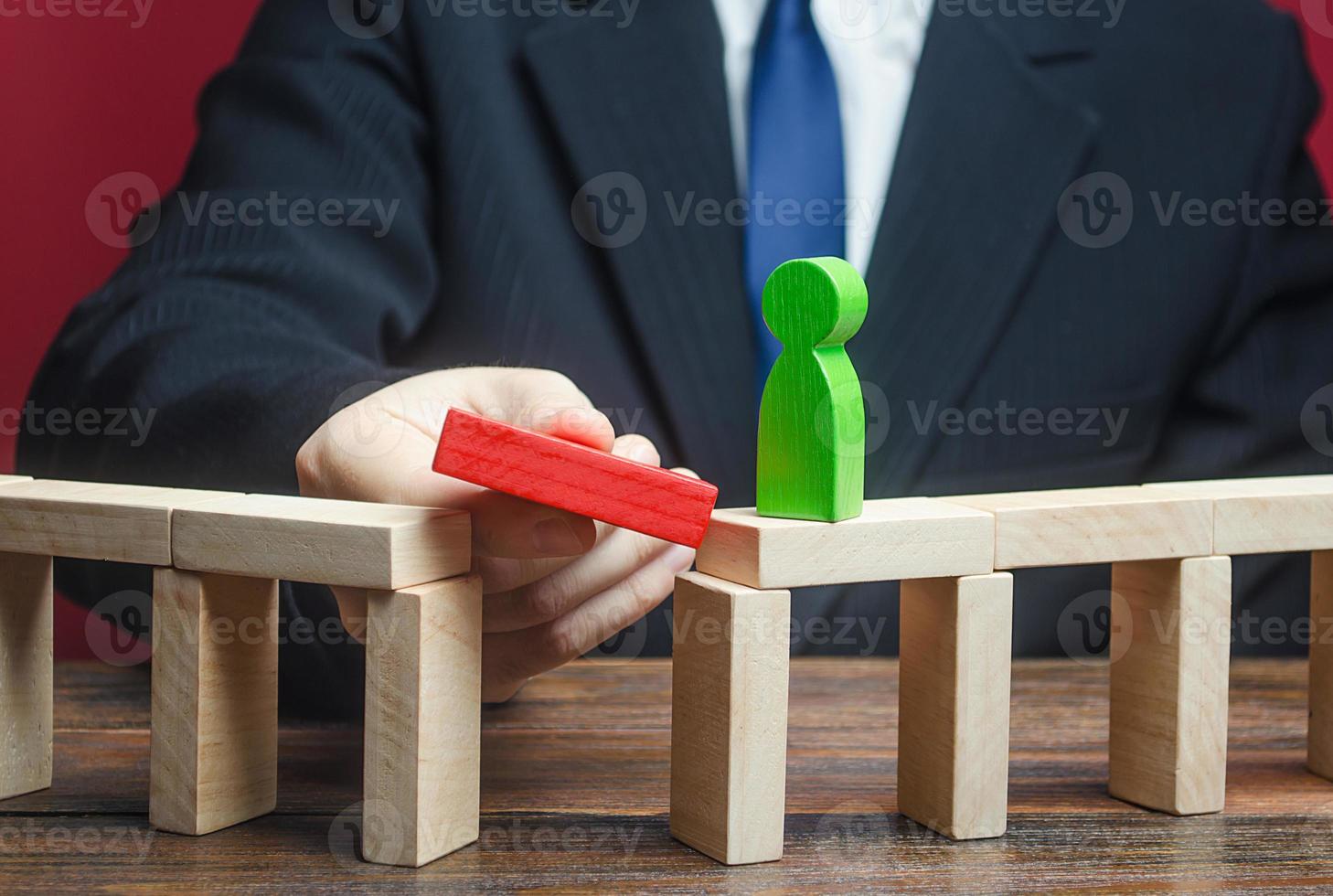 un homme d'affaires construit un chemin pour une figure verte. faire un chemin vers le succès, le soutien et l'aide financière. croissance de carrière et développement professionnel. éducation. créer une entreprise et une société. photo