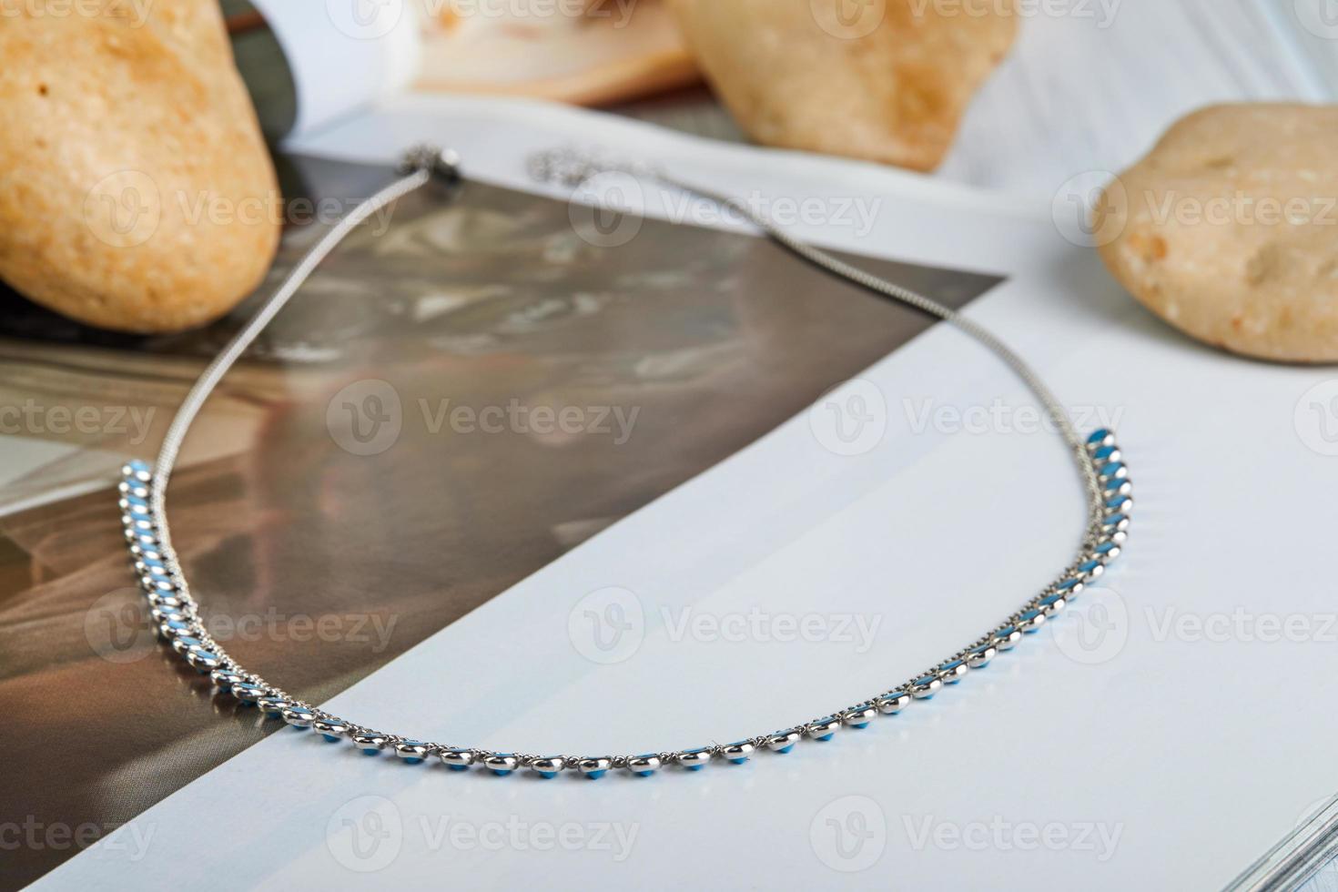 chaîne en argent avec pierres bleues sur fond gris-blanc photo