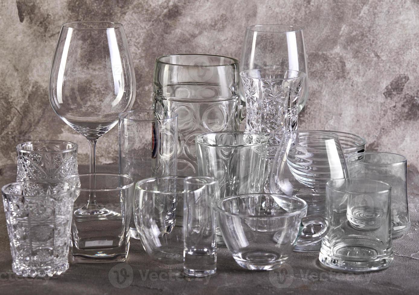 ensemble de verres de différentes tailles et pour différentes boissons sur fond de biton gris photo