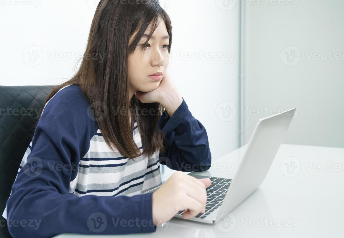 jeune étudiante assise dans le salon et apprenant en ligne photo