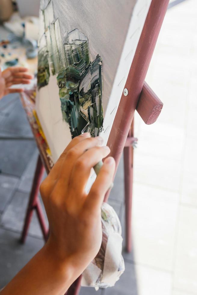 gros plan de la main d'une femme appliquant de la peinture sur une toile photo