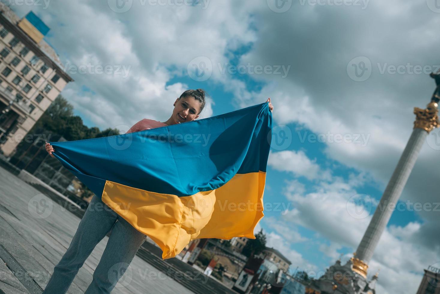 jeune femme avec le drapeau national de l'ukraine dans la rue photo