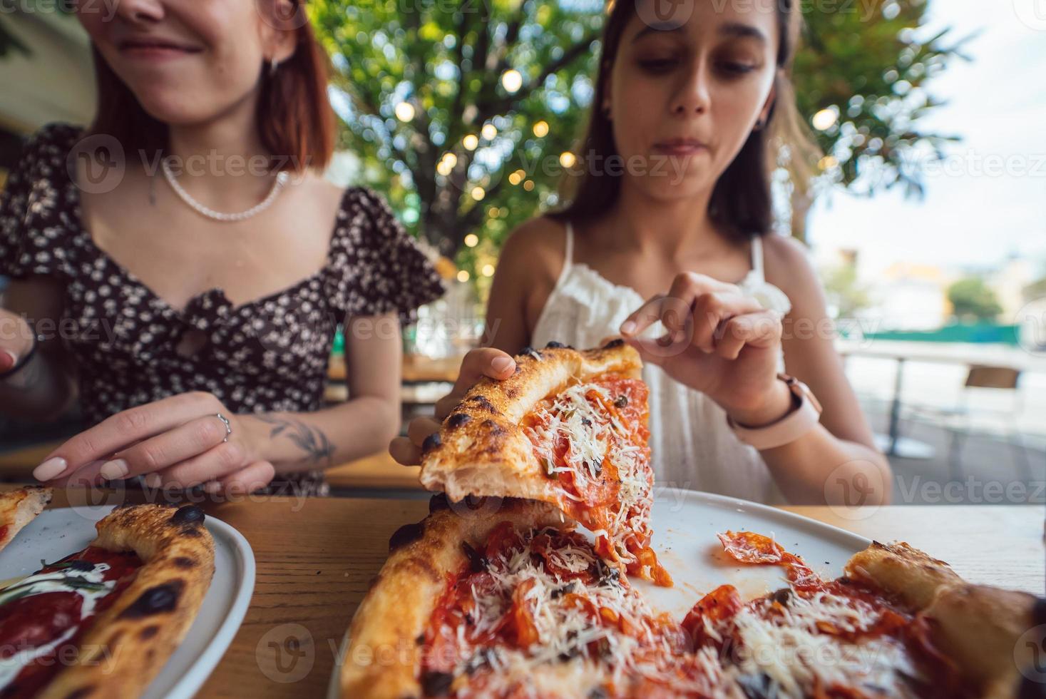 charmante belle femme prend une tranche de pizza. photo