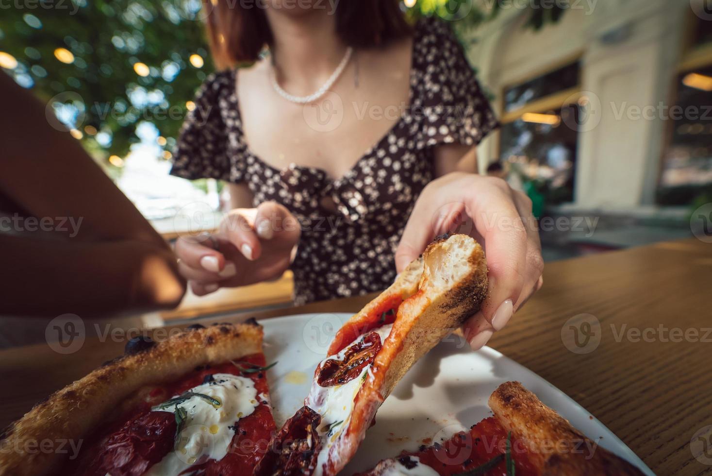charmante belle femme prend une tranche de pizza. photo