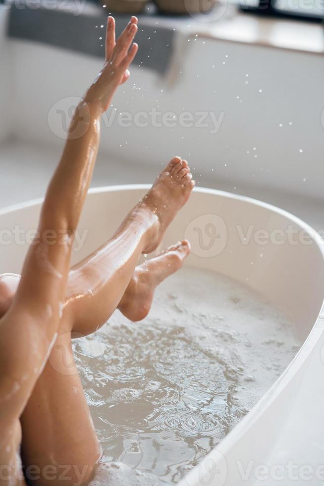 vue courte d'une jeune femme allongée dans un bain moussant photo
