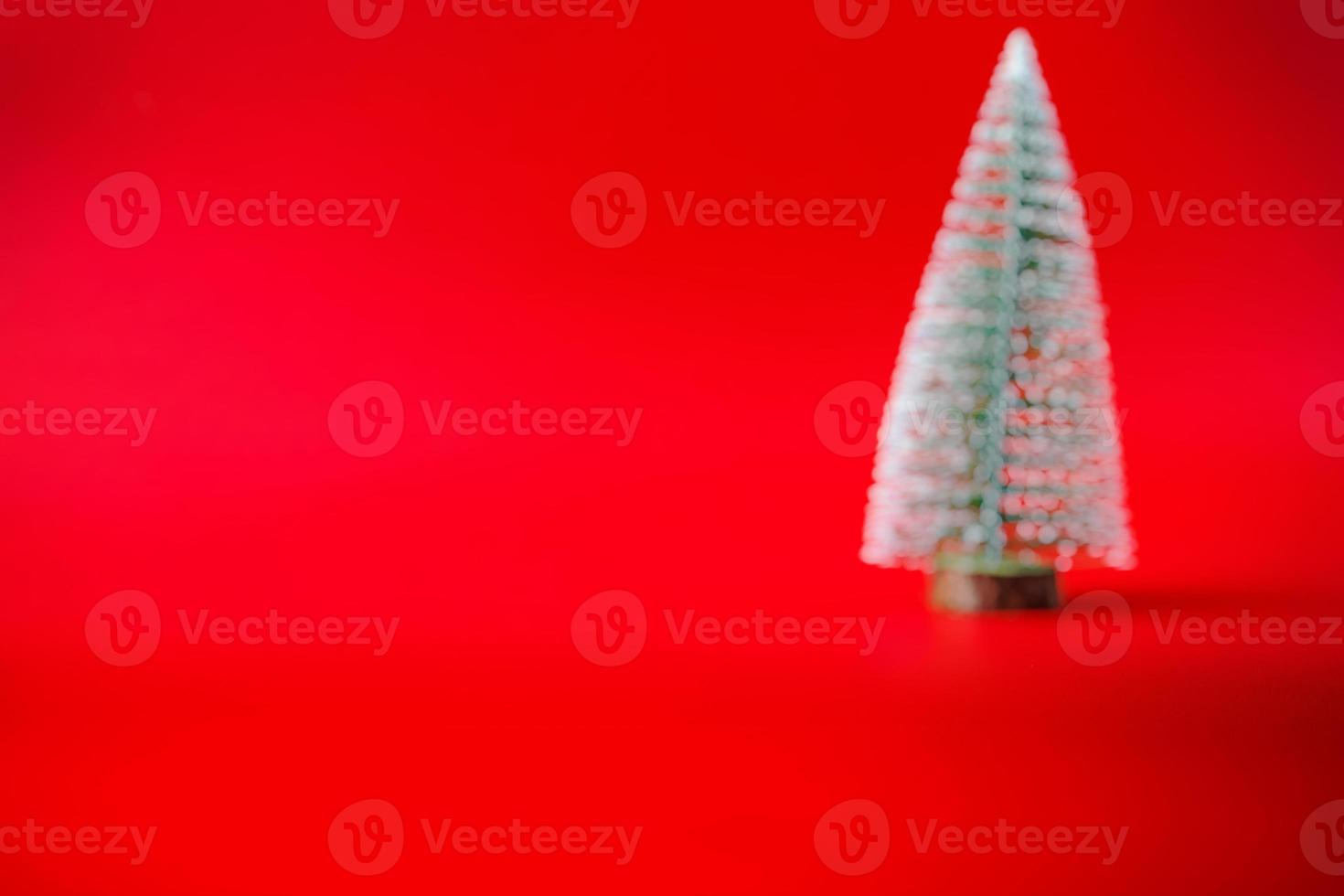 abstrait flou arbre de noël sur fond rouge concept de célébration de vacances de nouvel an photo