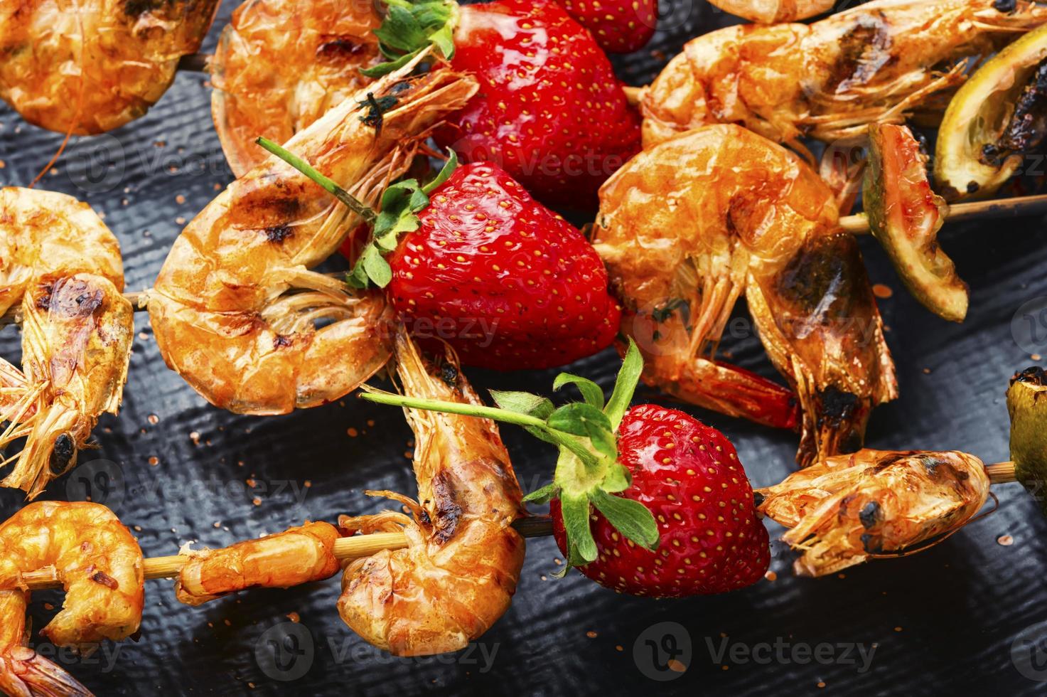 crevettes grillées sur brochettes avec fraises, crevettes bbq photo