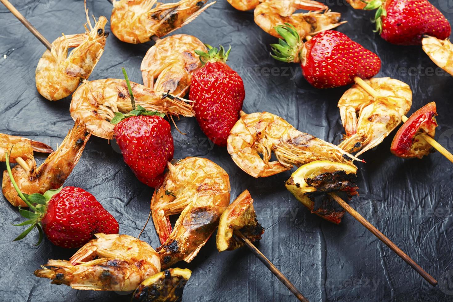 crevettes grillées sur brochettes avec fraises, crevettes bbq photo