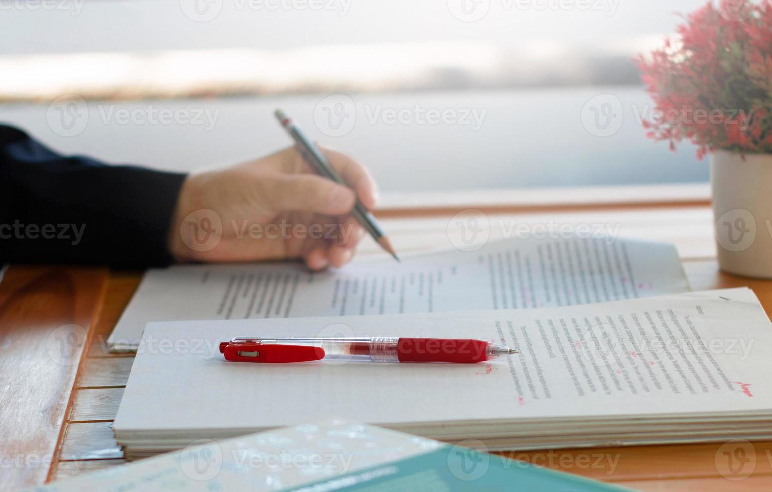 stylo rouge sur la paperasse floue et les livres photo