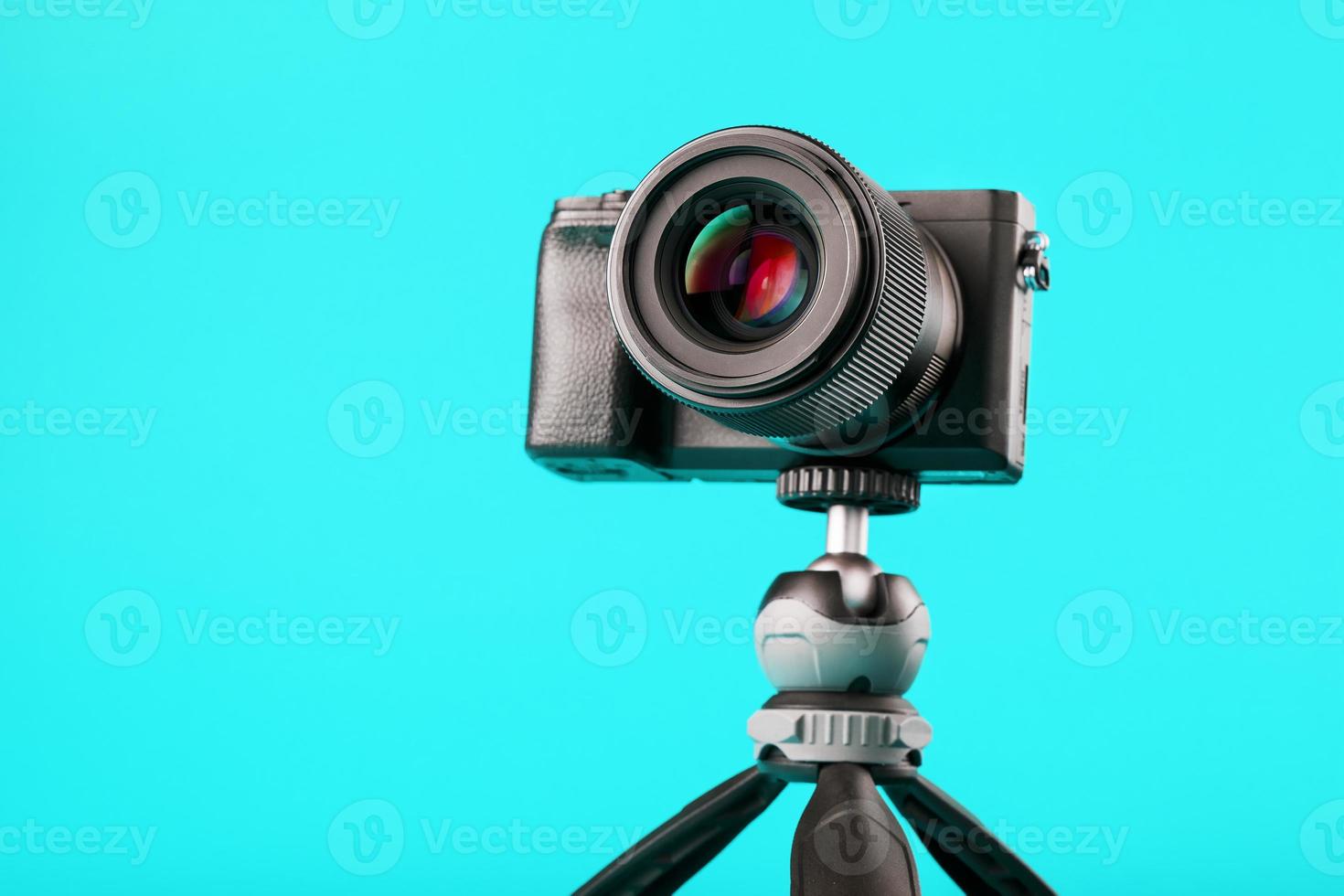 appareil photo professionnel sur trépied, sur fond bleu. enregistrer des vidéos et des photos pour votre blog ou rapport.