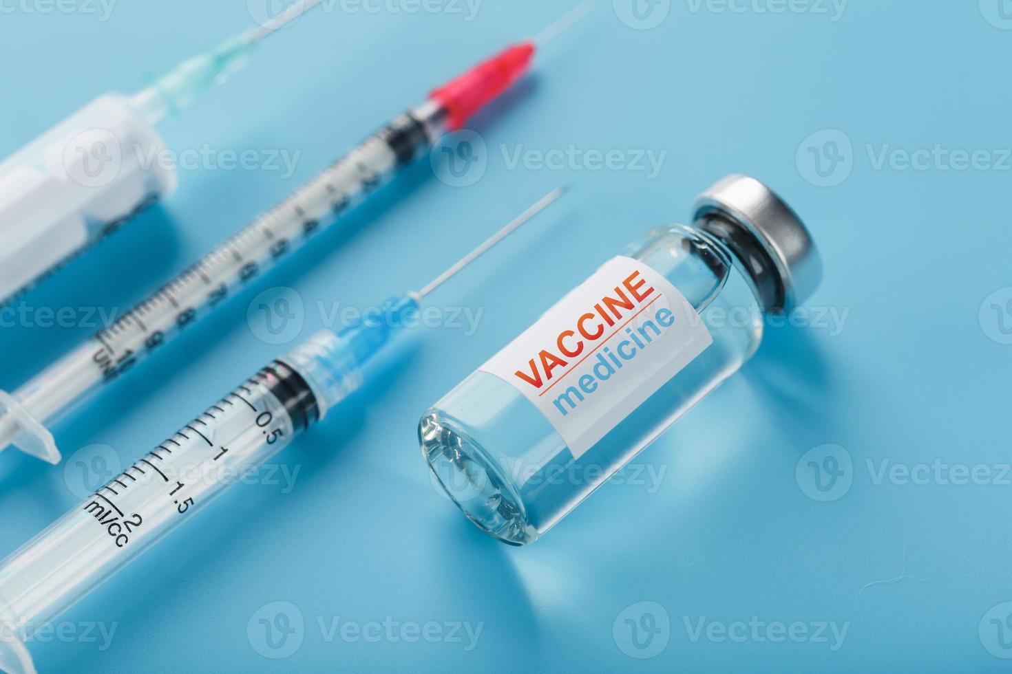 médicaments avec ampoule de vaccin à seringue sur fond bleu. photo