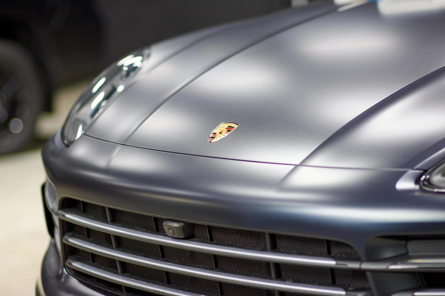 pose d'un film de protection peinture et vernis mat sur une voiture porsche cayenne noire. le film de polyuréthane ppf protège la peinture automobile des pierres, mise au point floue. tcheliabinsk, russie, 03 avril 2021 photo