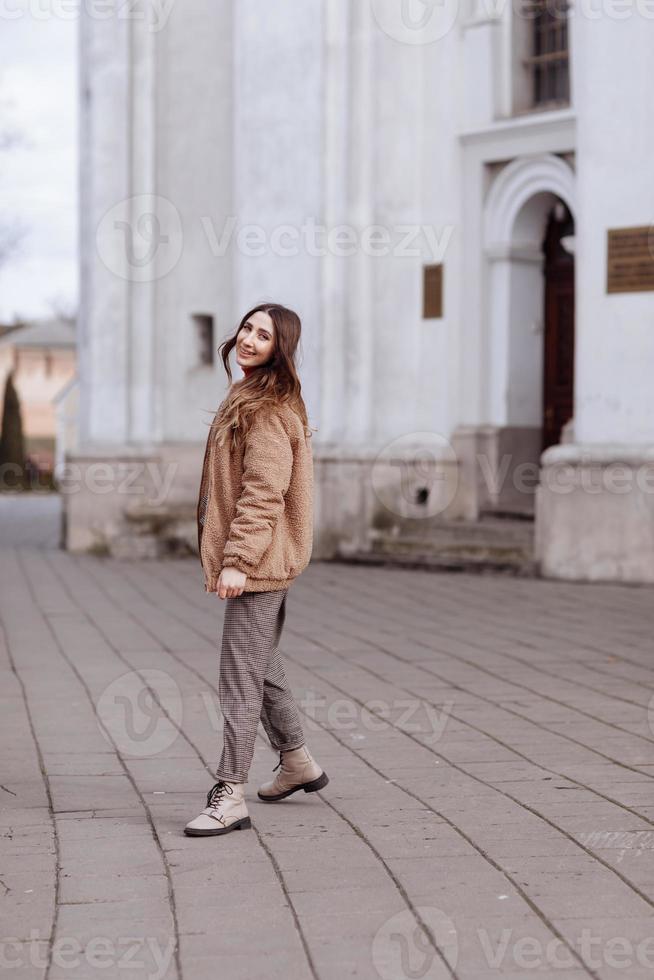 portrait de style de mode. belle fille élégante aux cheveux longs se promène dans la ville. portrait de jolie fille dans la rue. jour de printemps ou d'automne. mise au point sélective. photo