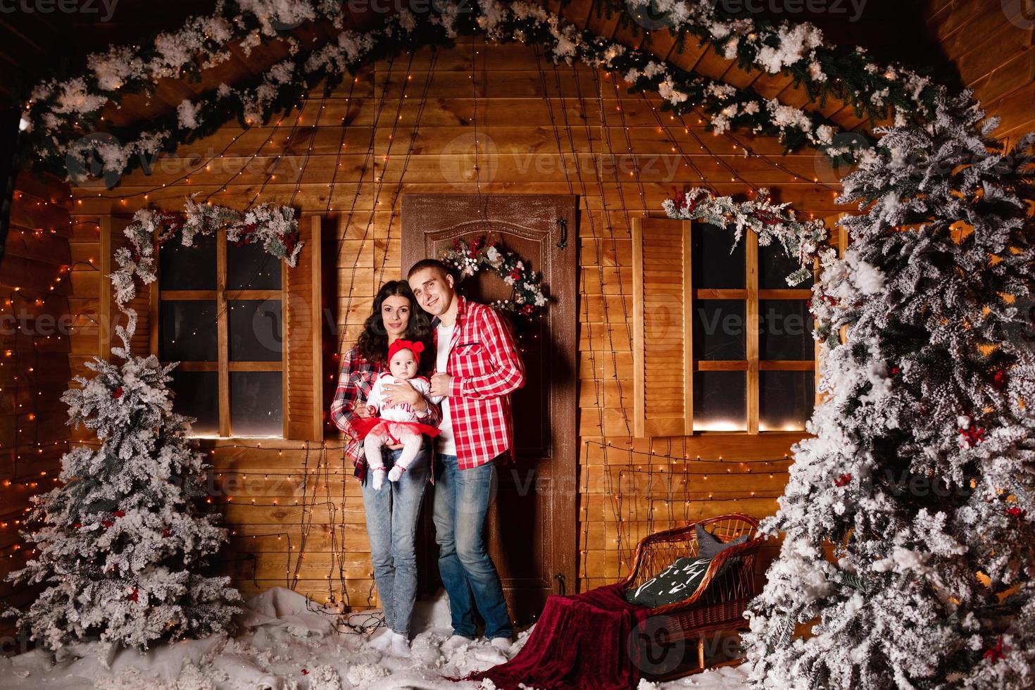 maman et papa posent avec leur charmante petite fille dans un studio de noël décoré. séance photo du nouvel an.