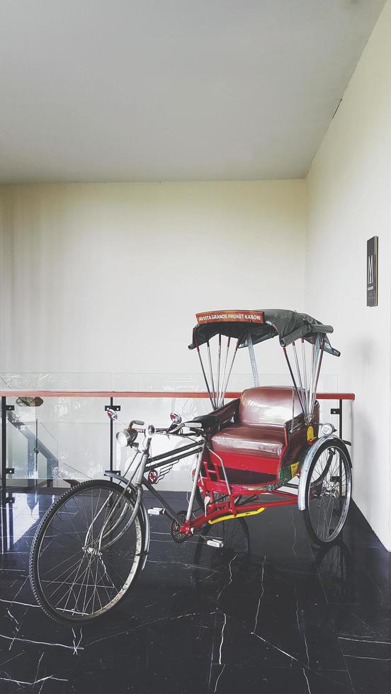 vélo tricycle rétro de style thaïlandais ou pousse-pousse garé et spectacle pour le client à l'hôtel avec fond de mur dans un ton vintage. véhicule asiatique et type de vélo pour ramasser les passagers et les touristes vers les sites touristiques photo