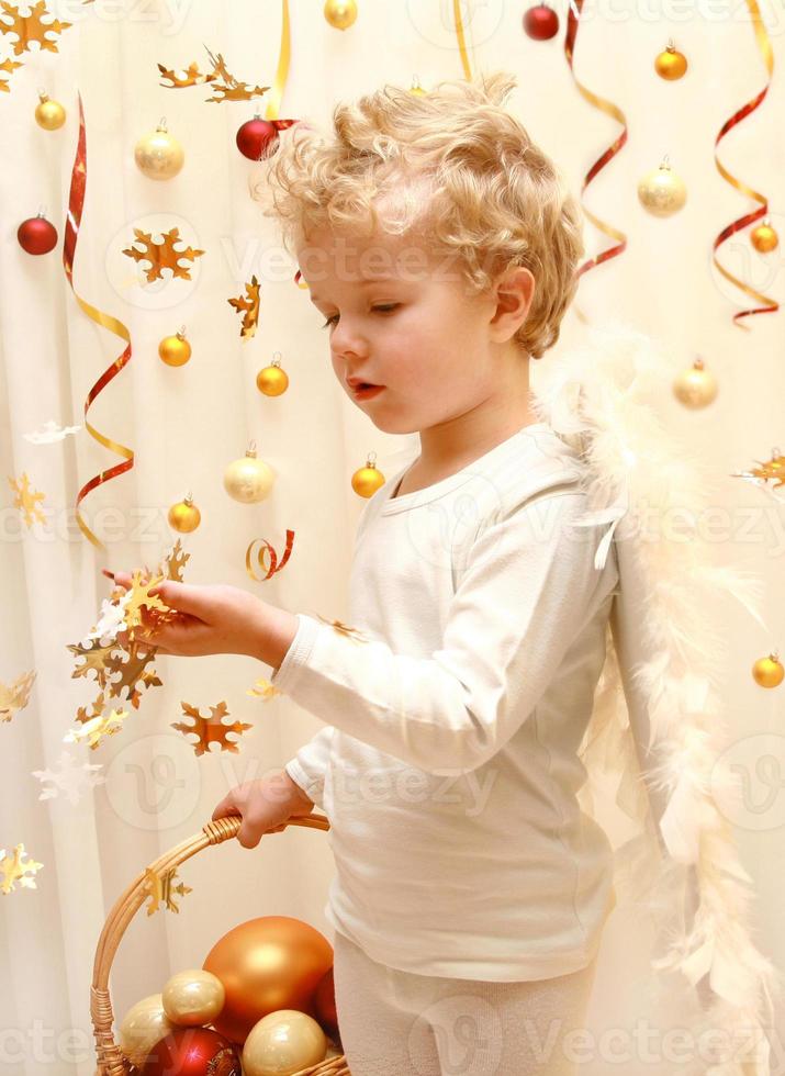 doux ange garçon avec des confettis étoiles d'or photo