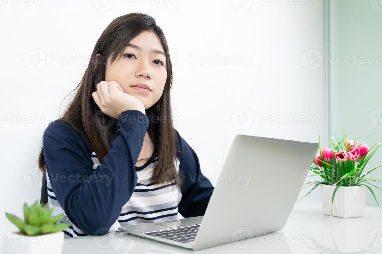 jeune étudiante assise dans le salon et apprenant en ligne photo