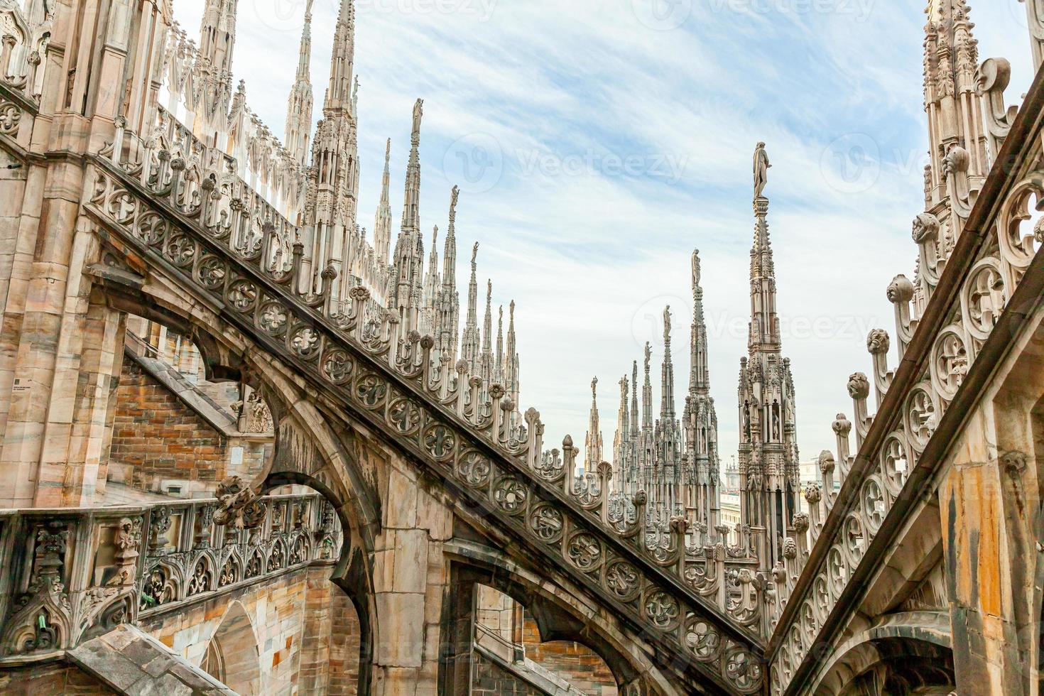 toit de la cathédrale de milan duomo di milano avec des flèches gothiques et des statues de marbre blanc. principale attraction touristique sur la piazza à milan, lombardie, italie. vue grand angle de l'architecture et de l'art gothiques anciens. photo