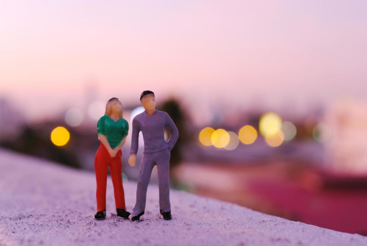 couple miniature personnes figure debout sur le toit en voyant le coucher du soleil sur la ville, concept de la saint-valentin photo