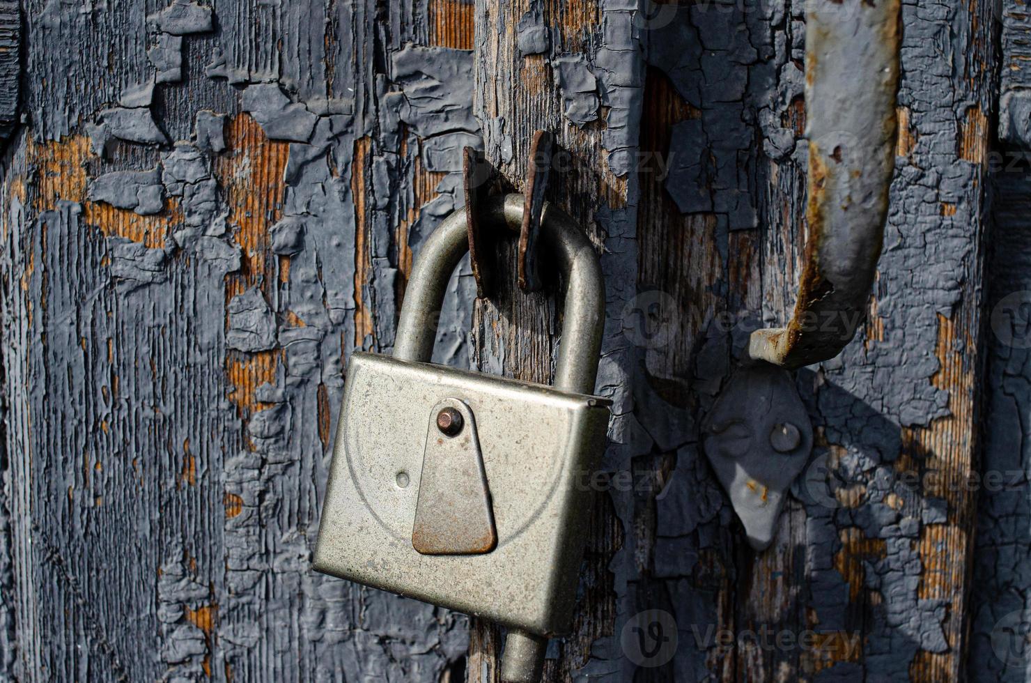 Serrure sur une vieille porte en bois avec inserts rouillés photo