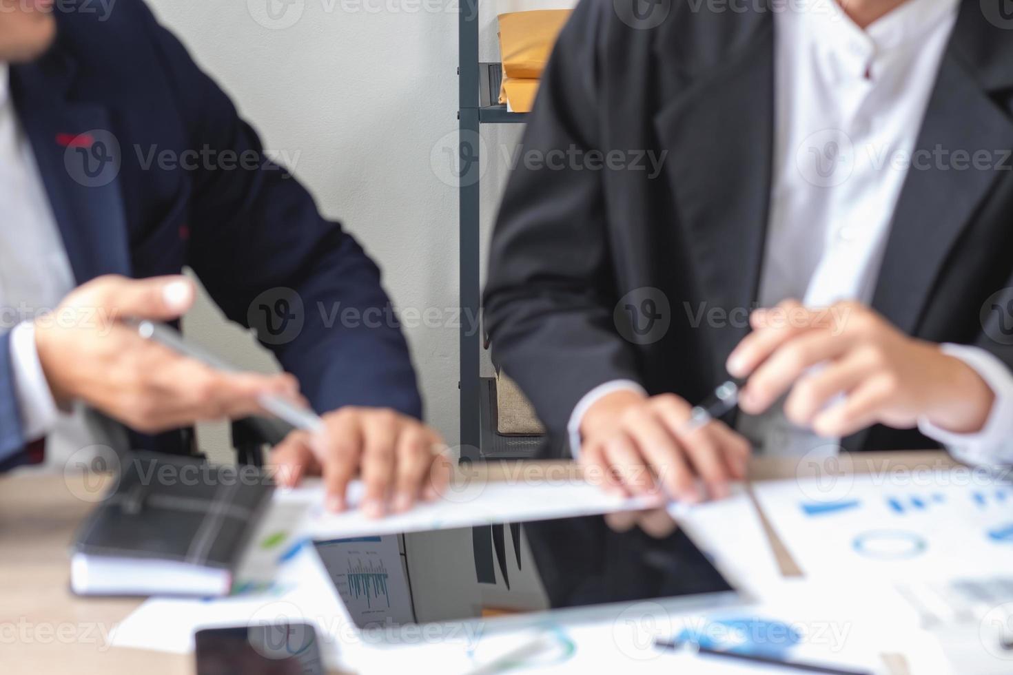 l'équipe d'affaires utilise des calculatrices et des tablettes d'ordinateur portable d'analyse graphique pour planifier des stratégies de marketing et faire des investissements rentables pour l'entreprise. photo