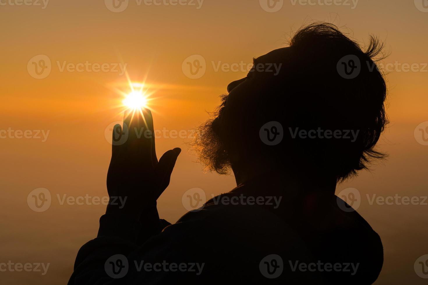 concept chrétien adorer ou prier dieu. silhouette d'homme chrétien avec amour, foi, dévotion à dieu avec fond de ciel de lever de soleil.dieu de culte masculin pour la paix, la victoire, le succès avec espoir. la religion photo