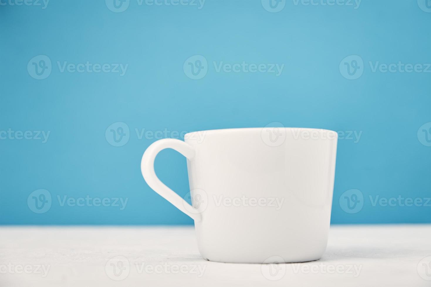 tasse blanche sur fond bleu avec espace de copie photo