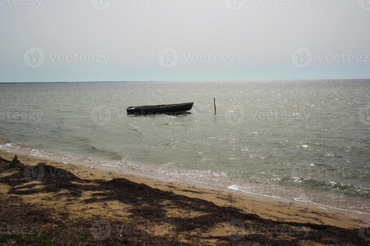 un vieux bateau de pêche, debout sur l'eau, attendant le pêcheur. photo