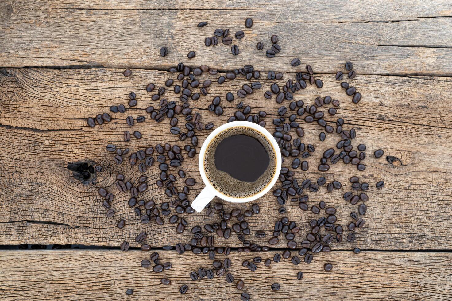 tasse à café et grains de café sur le bureau, vue du dessus photo