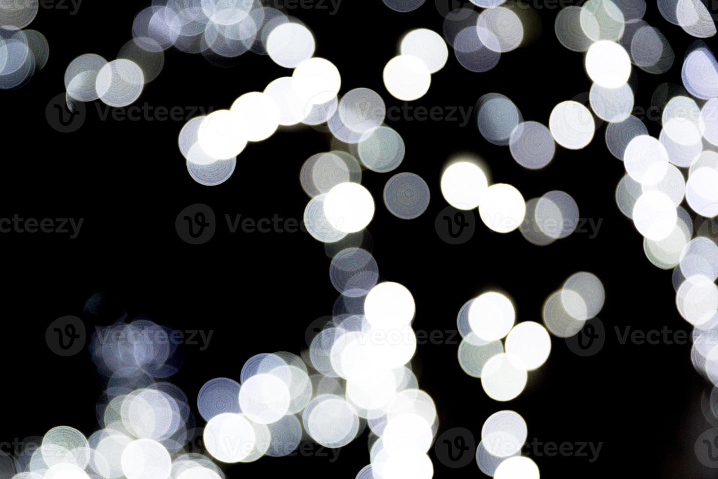 bokeh blanc abstrait non focalisé sur fond noir. défocalisé et flou beaucoup de lumière ronde photo