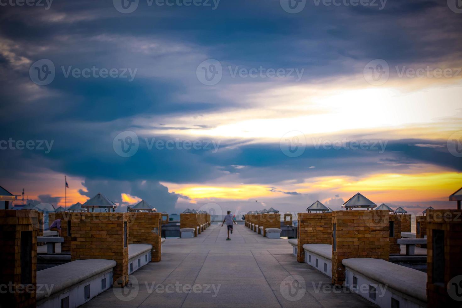 magnifique coucher de soleil sur la mer longue exposition sur la jetée et les promenades en skateboard photo