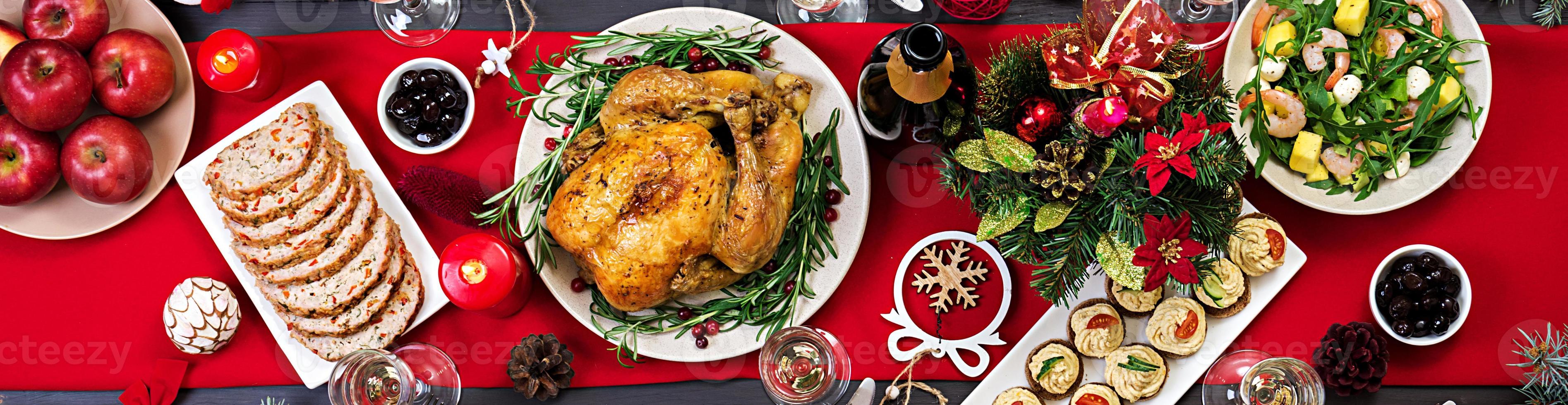 dinde au four. dîner de Noël. la table de noël est servie avec une dinde, décorée de guirlandes lumineuses et de bougies. poulet frit, table. dîner de famille. vue de dessus photo