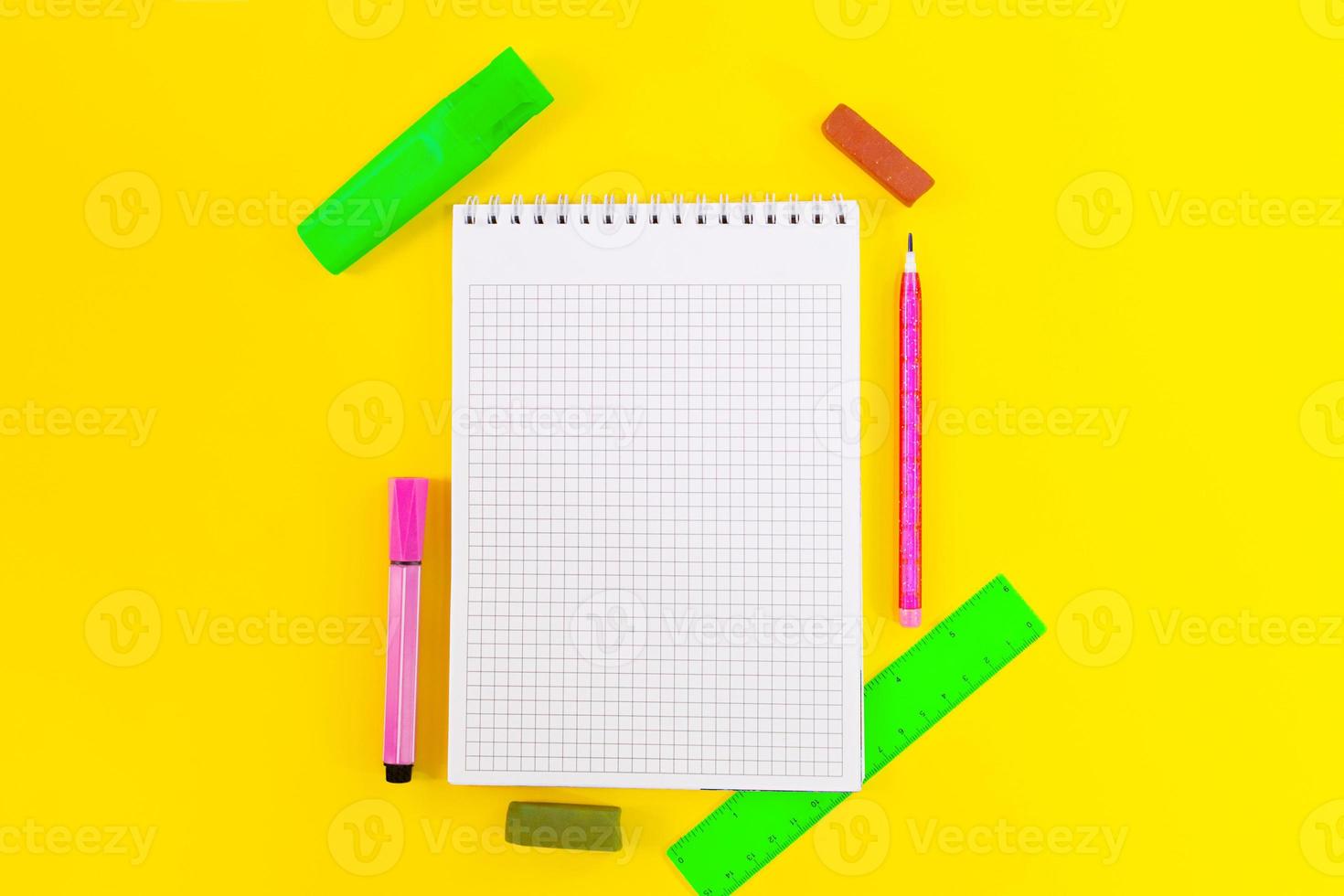 retour à l'école. éducation. cellule de cahier pour notes, marqueurs, crayons, crayon, règle sur fond jaune. mise à plat. copie espace photo