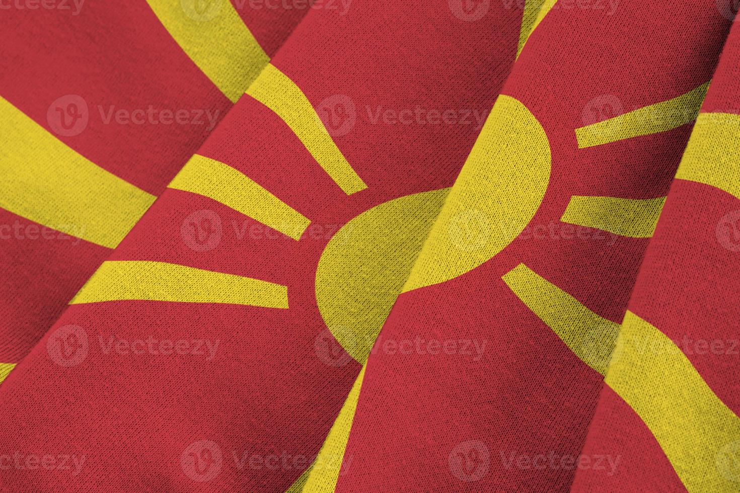 drapeau macédoine avec de grands plis agitant de près sous la lumière du studio à l'intérieur. les symboles et couleurs officiels de la bannière photo