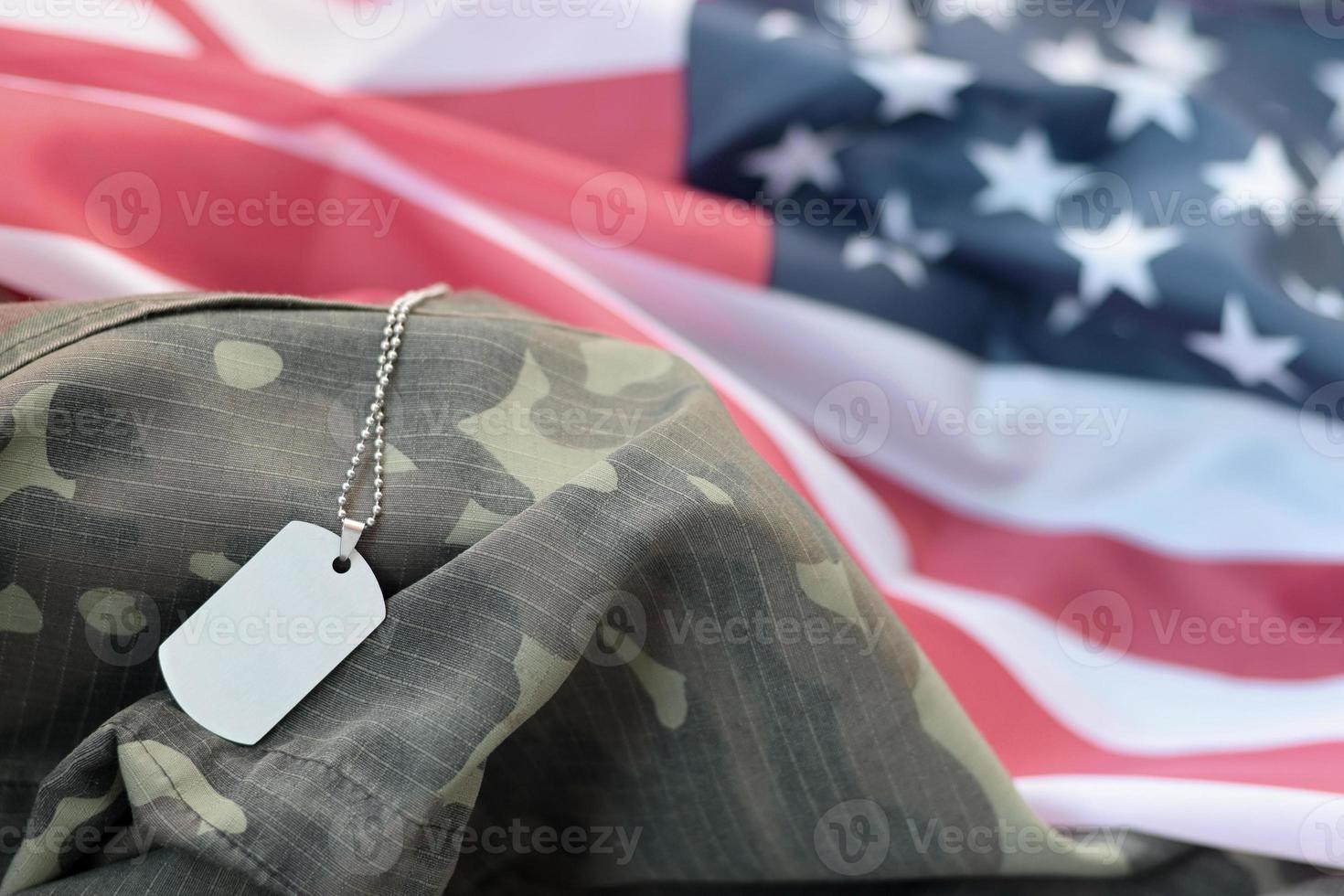 Perles militaires argentées avec étiquette de chien sur le drapeau en tissu des États-Unis et uniforme de camouflage photo