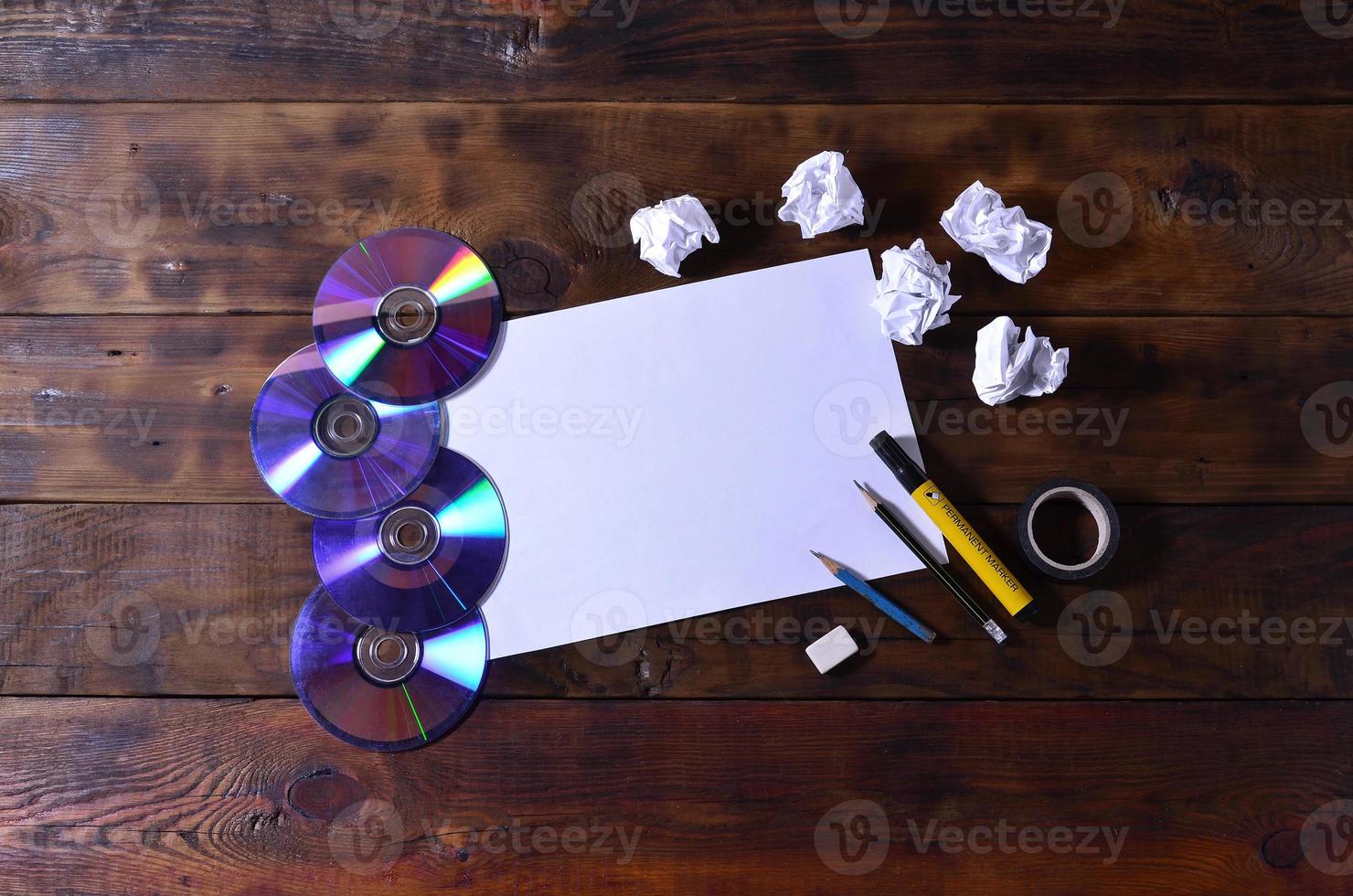 une école ou un bureau nature morte avec une feuille de papier vierge blanche et de nombreuses fournitures de bureau. les fournitures scolaires se trouvent sur un fond en bois marron. place pour le texte photo