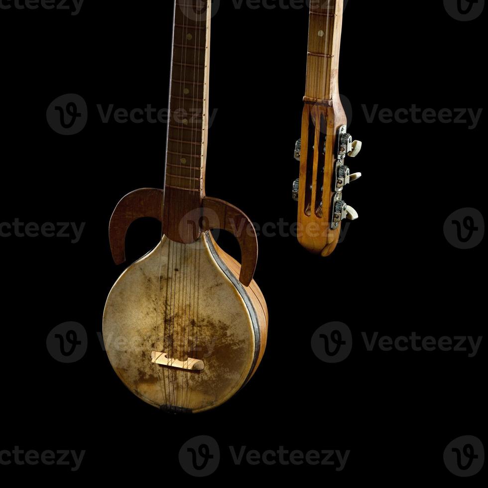 un ancien instrument de musique à cordes asiatique sur fond noir photo